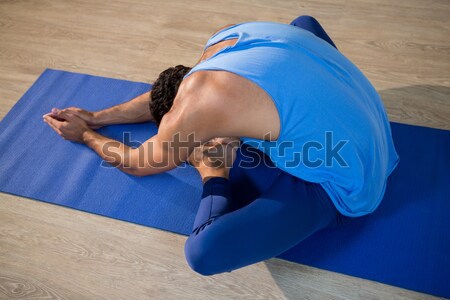 Woman doing cross legged forward fold on exercise mat Stock photo © wavebreak_media