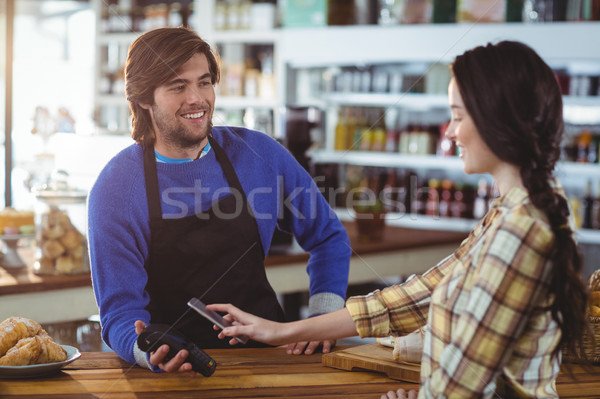 Woman paying bill through smartphone using NFC technology Stock photo © wavebreak_media