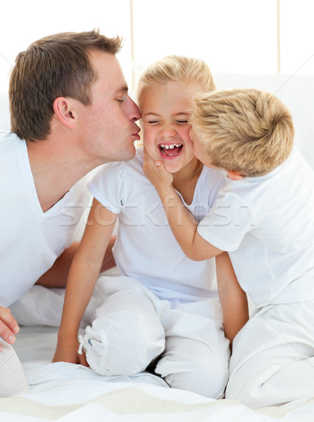 Stock photo: Loving family playing sitting on a bed