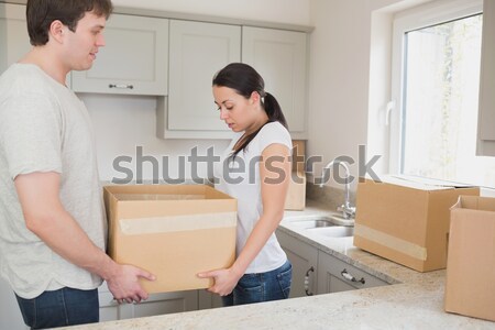 dark-haired woman taping boxes looking at the camera Stock photo © wavebreak_media