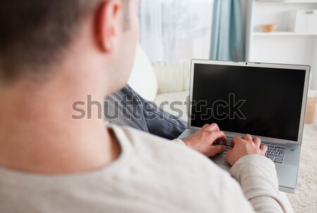 Homme canapé utilisant un ordinateur portable salon ordinateur maison Photo stock © wavebreak_media