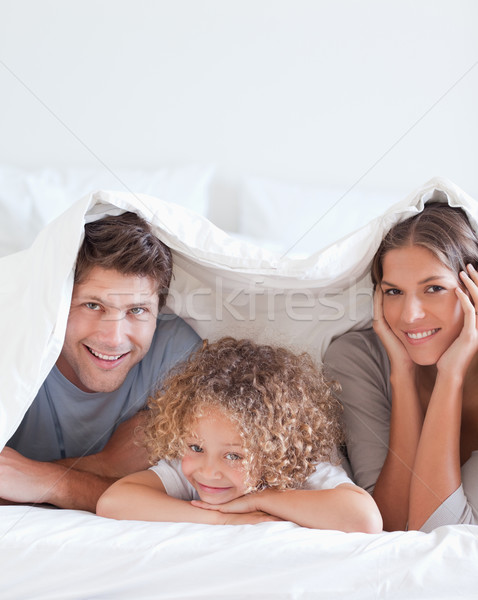 Smiling family lying in bed together Stock photo © wavebreak_media