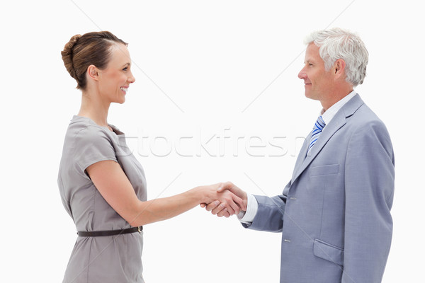 Stock photo: Close-up of a white hair man face to face and shaking hands with a woman against white background