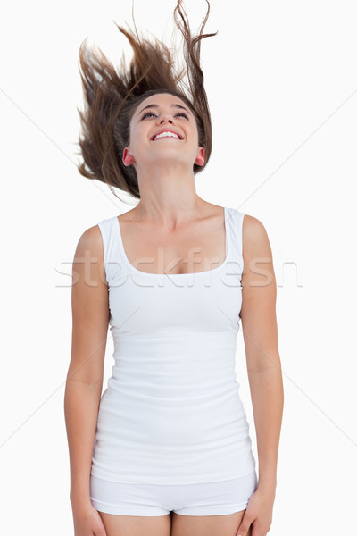 Smiling woman standing with her hair elevated against a white background Stock photo © wavebreak_media