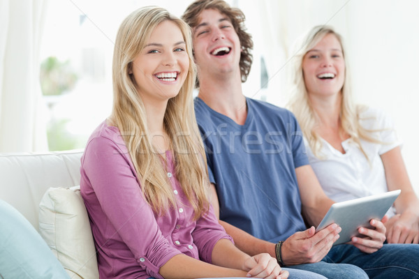 Trei râs prietenii sta canapea Imagine de stoc © wavebreak_media