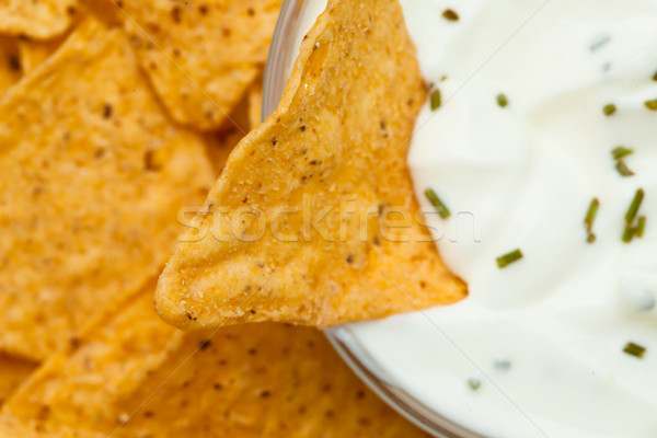 Close up of a nacho dipped into a bowl of dip with herbs Stock photo © wavebreak_media