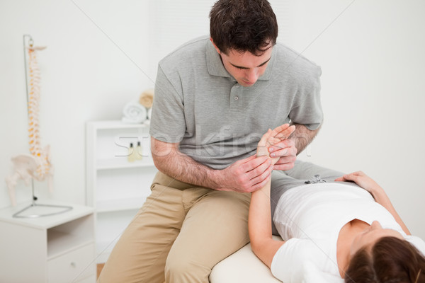 Serious physiotherapist holding the hand of a woman in a medical room Stock photo © wavebreak_media