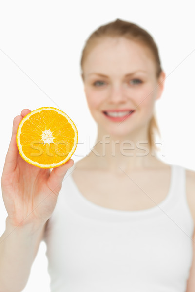 Blonde-haired woman holding an orange against white background Stock photo © wavebreak_media