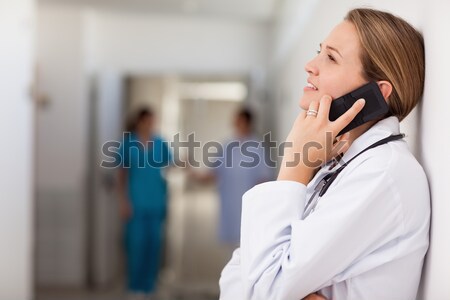 Doctor against a wall phoning in a hallway Stock photo © wavebreak_media