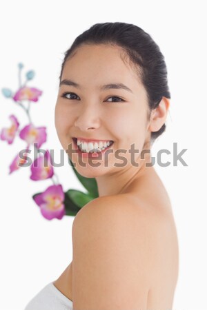 Woman smiling at camera while holding orchids Stock photo © wavebreak_media