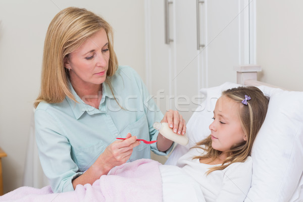 Mother giving her daughter cough medicine Stock photo © wavebreak_media
