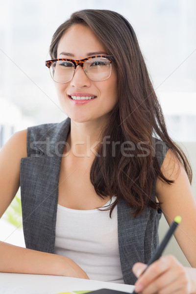 Stock photo: Casual female photo editor using graphics tablet