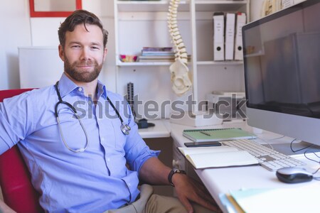 Dentist smiling at camera beside chair Stock photo © wavebreak_media