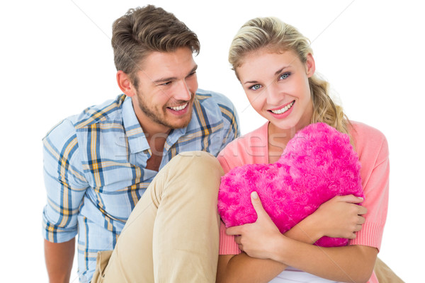 Attractive young couple sitting holding heart cushion Stock photo © wavebreak_media