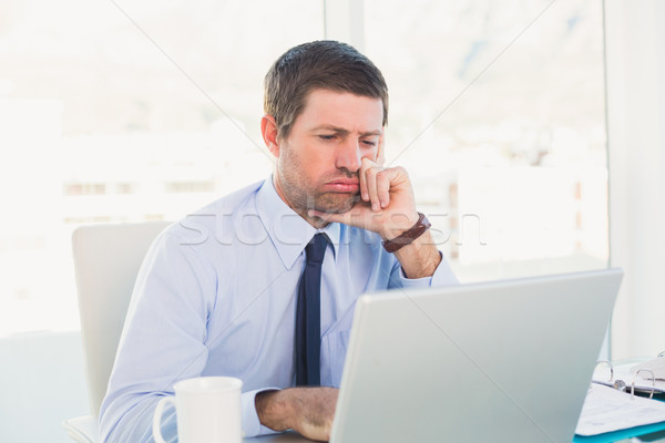 Confused businessman looking at his laptop Stock photo © wavebreak_media