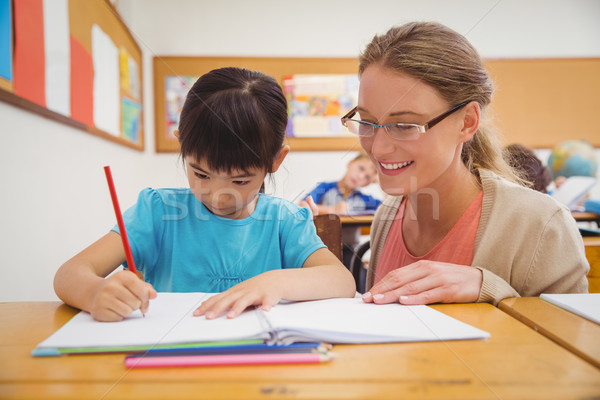 Pretty teacher helping pupil in classroom Stock photo © wavebreak_media