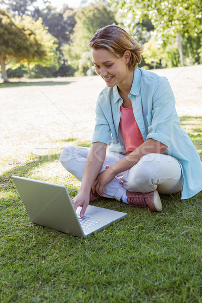 Stock photo: Pretty woman using laptop in park