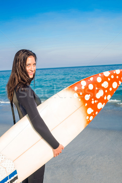 Kobieta deska surfingowa patrząc kamery plaży Zdjęcia stock © wavebreak_media