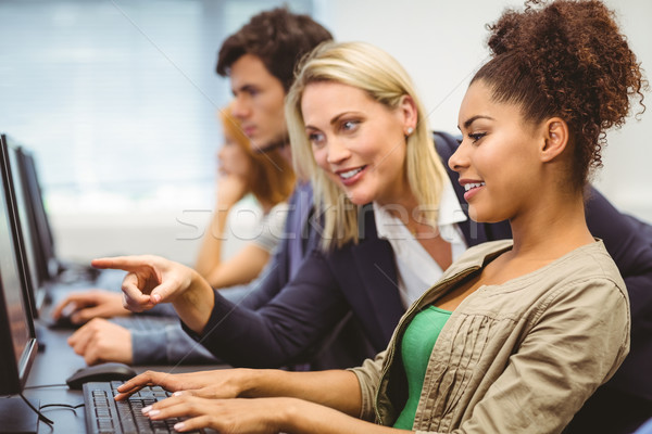 Attractive teacher talking to her student in computer class Stock photo © wavebreak_media