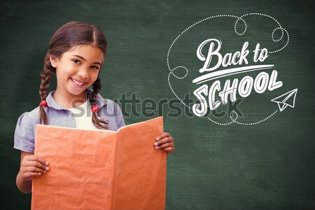 Female student holding book against chalkboard Stock photo © wavebreak_media