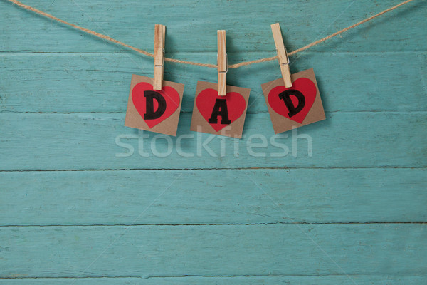 Text dad in heart shapes hanging on green wall Stock photo © wavebreak_media