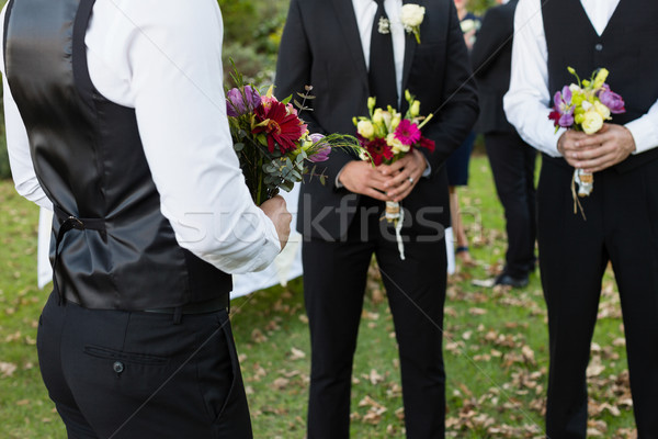 Bridegroom and best man standing with bouquet of flowers in garden Stock photo © wavebreak_media