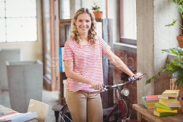 Stock photo: Portrait of businesswoman with bicycle in office