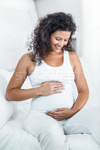 Hamile kadın dokunmak gülen oturma yatak Stok fotoğraf © wavebreak_media