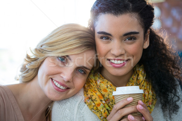 Portrait of female friends sitting together and having coffee Stock photo © wavebreak_media