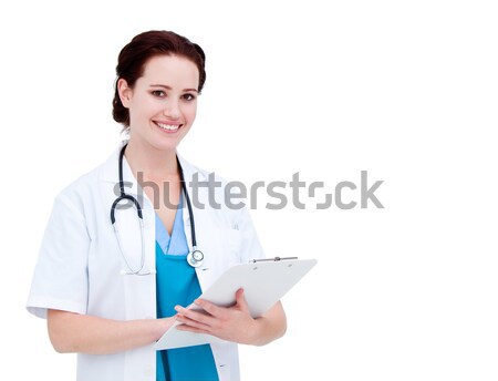 Stock photo: Assertive female doctor making notes in a patient's folder