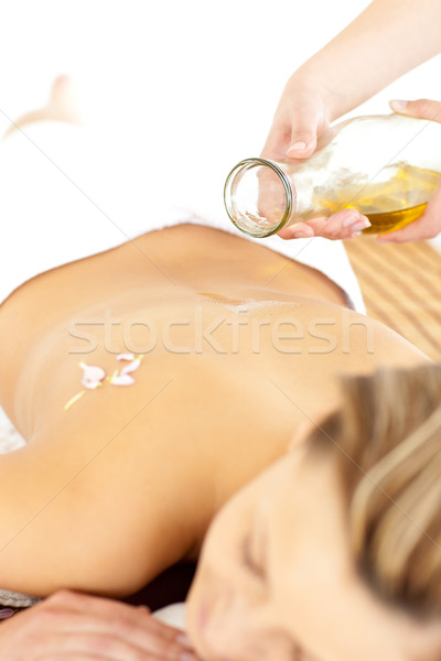 Glad young woman enjoying a back massage with oil in a spa center Stock photo © wavebreak_media