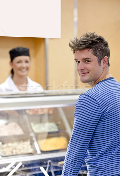 Handsome customer standing in the queue in a cafeteria smiling at the camera  Stock photo © wavebreak_media
