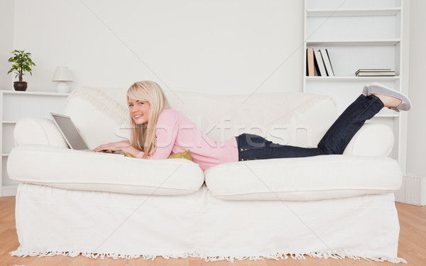 Foto stock: Jóvenes · mujer · rubia · posando · portátil · sofá · salón