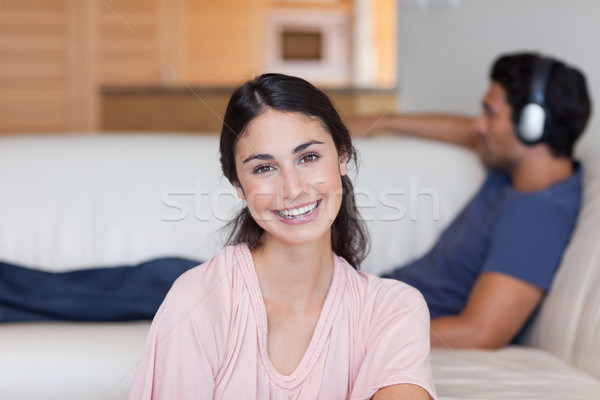 Woman posing while her fiance is listening to music in their living room Stock photo © wavebreak_media