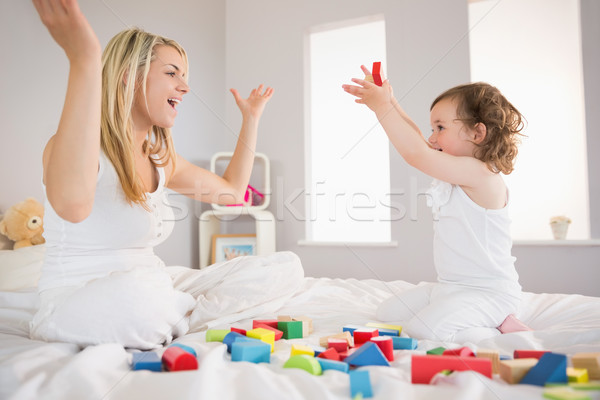 Mère fille jouer blocs de construction lit vue de côté [[stock_photo]] © wavebreak_media