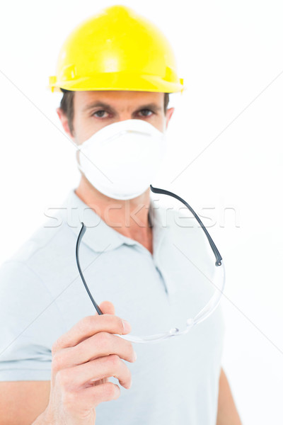 Worker wearing mask and hardhat while holding protective glasses Stock photo © wavebreak_media