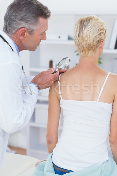 Doctor examining his patient with magnifying glass  Stock photo © wavebreak_media