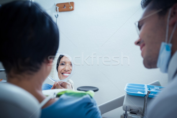Smiling young woman looking at mirror Stock photo © wavebreak_media