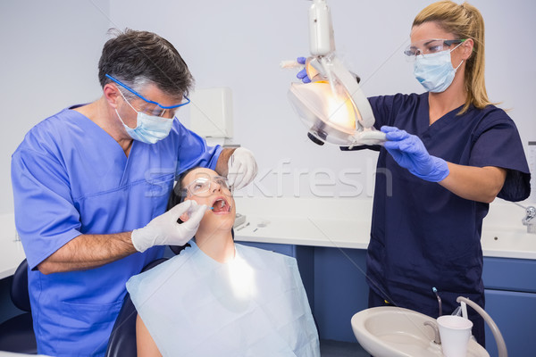 Dentist doing injection to his patient and nurse adjusting the l Stock photo © wavebreak_media