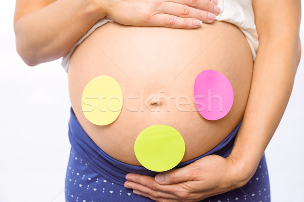 Pregnant woman with stickers on bump Stock photo © wavebreak_media