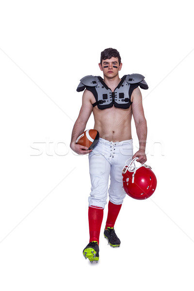 Stock photo: American football player walking with a ball and helmet