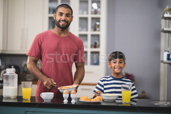 Portrait of happy father and his son having breakfast in kitchen Stock photo © wavebreak_media