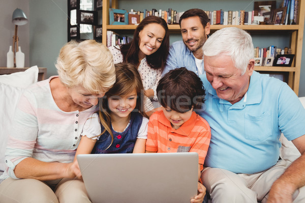 Souriant enfants grands-parents utilisant un ordinateur portable famille maison de famille [[stock_photo]] © wavebreak_media