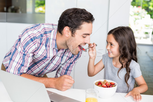 Stock photo: Smiling daughter feeding food to father 