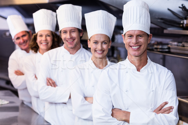 Happy chefs team standing together in commercial kitchen Stock photo © wavebreak_media