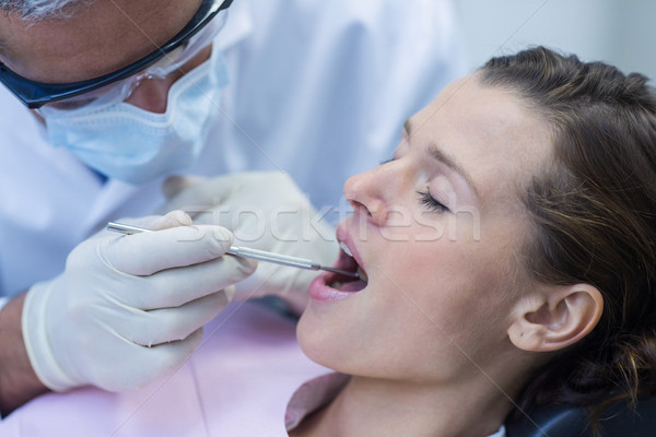 Dentist examining a patient with tools Stock photo © wavebreak_media
