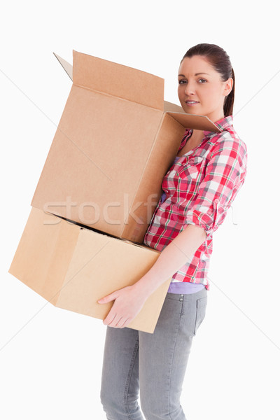 Good looking woman holding cardboard boxes while standing against a white background Stock photo © wavebreak_media