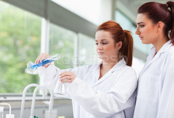 Science students pouring liquid in an Erlenmeyer flask in a laboratory Stock photo © wavebreak_media