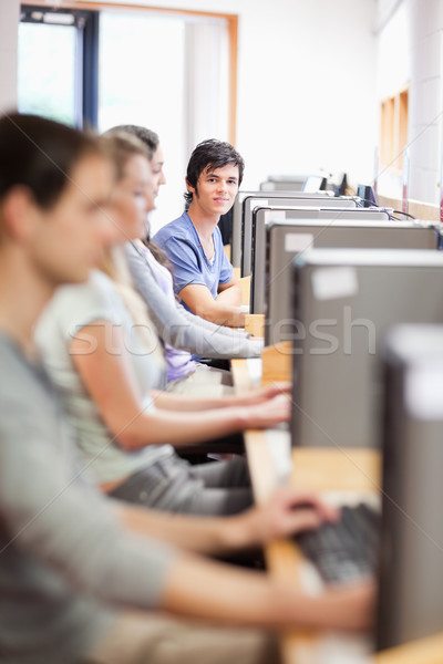 Portrait of young fellow students in an IT room with the camera focus on the background Stock photo © wavebreak_media