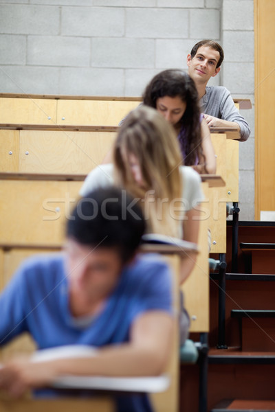 Portrait of young students writing in an amphitheater with the camera focus on the background Stock photo © wavebreak_media